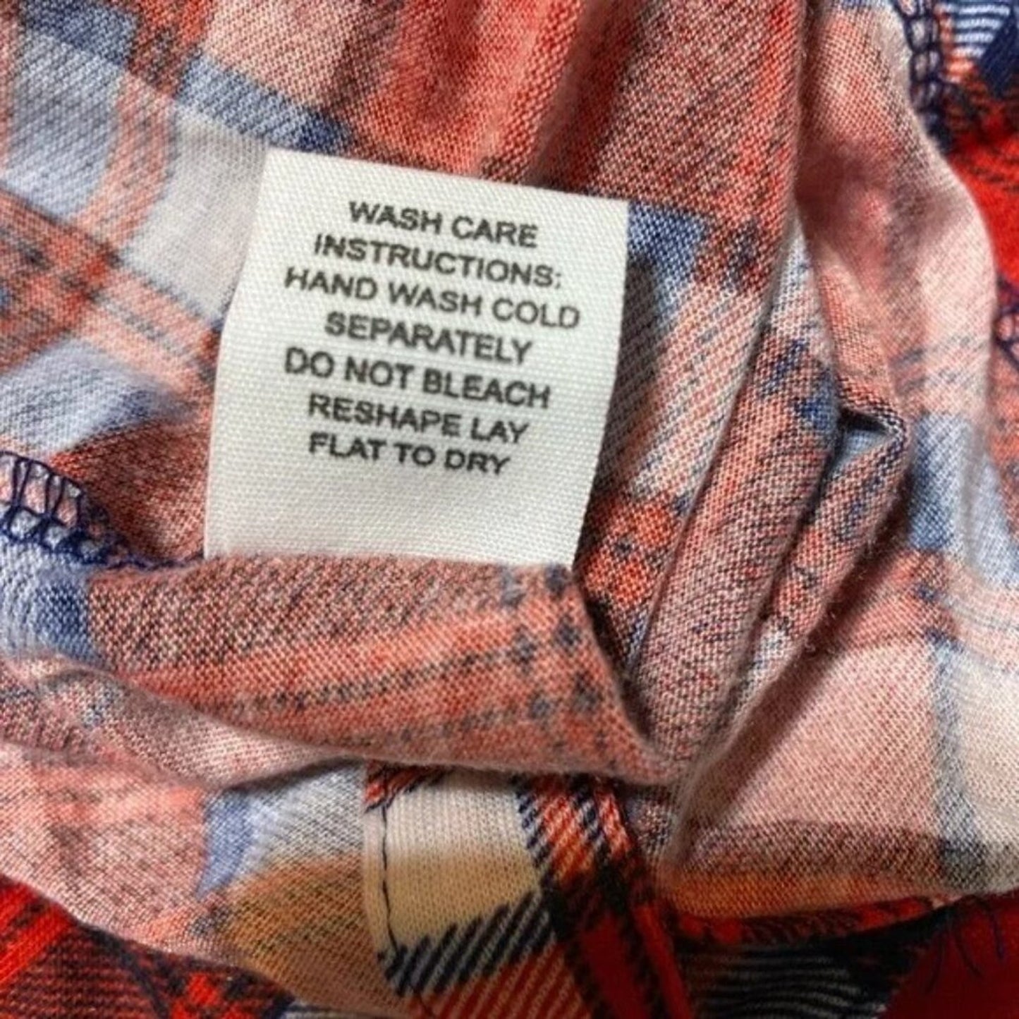 Wash care label on a plaid fabric with care instructions.