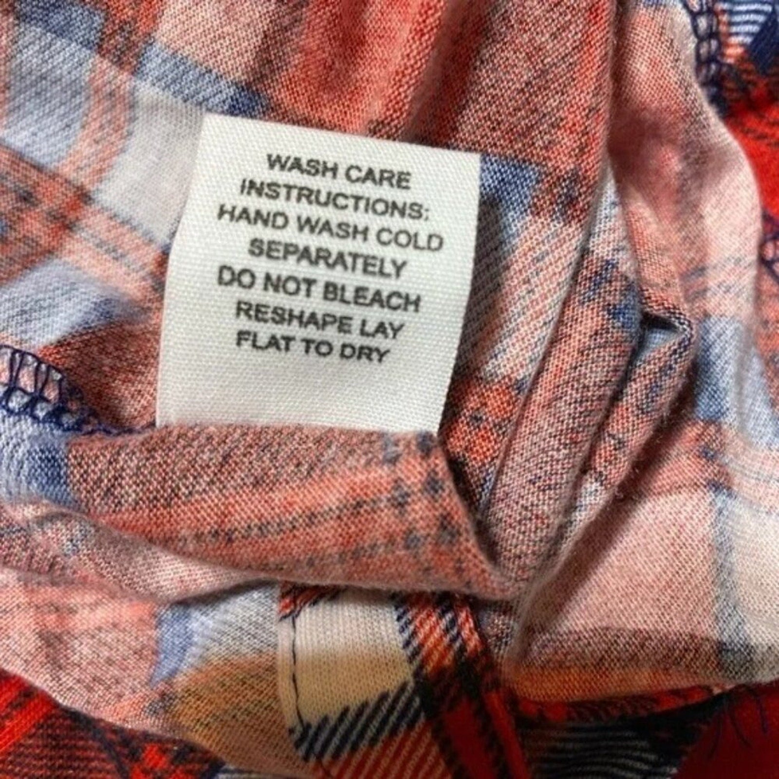 Wash care label on a plaid fabric with care instructions.