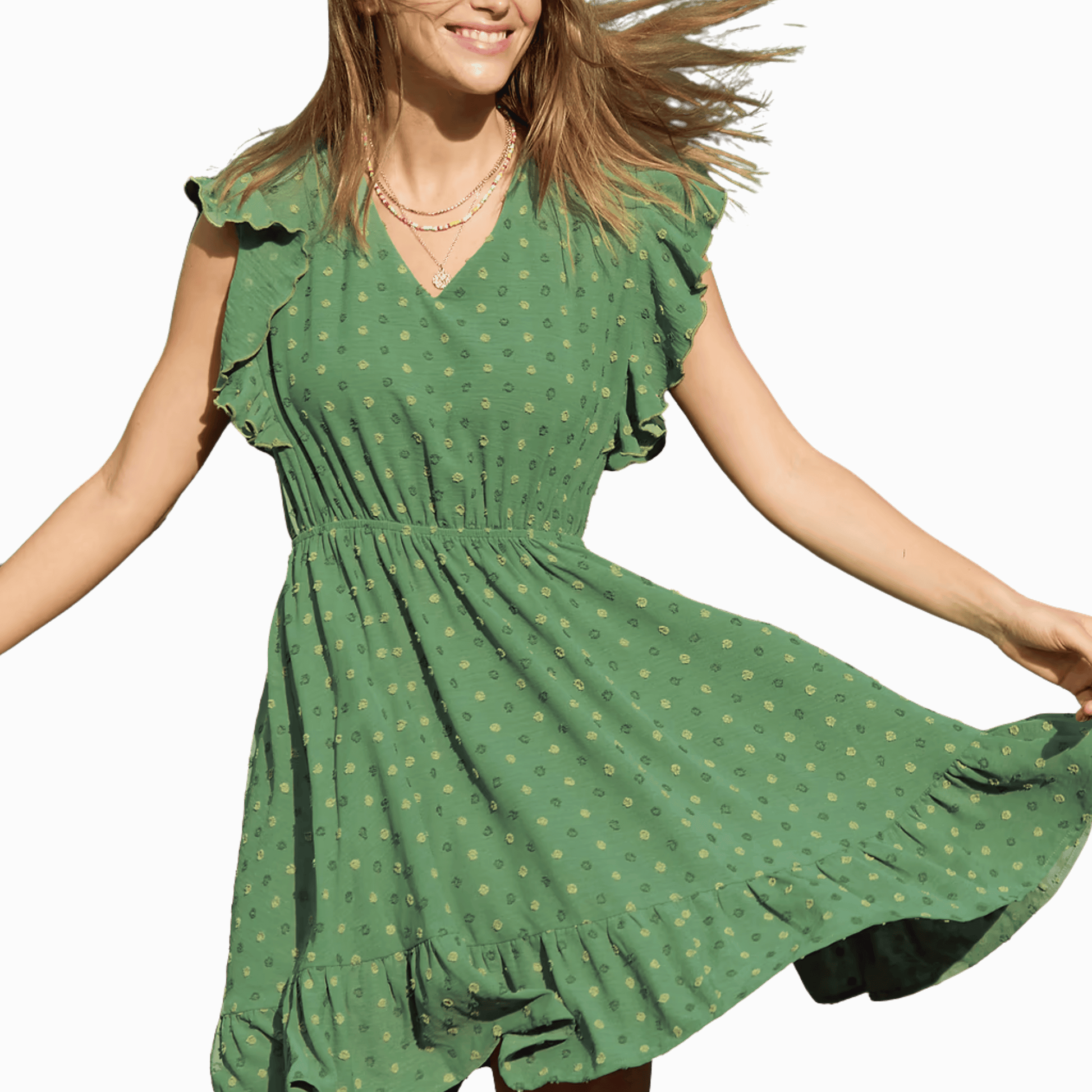 Woman wearing a green dress with a subtle pattern, smiling and twirling against a black background.