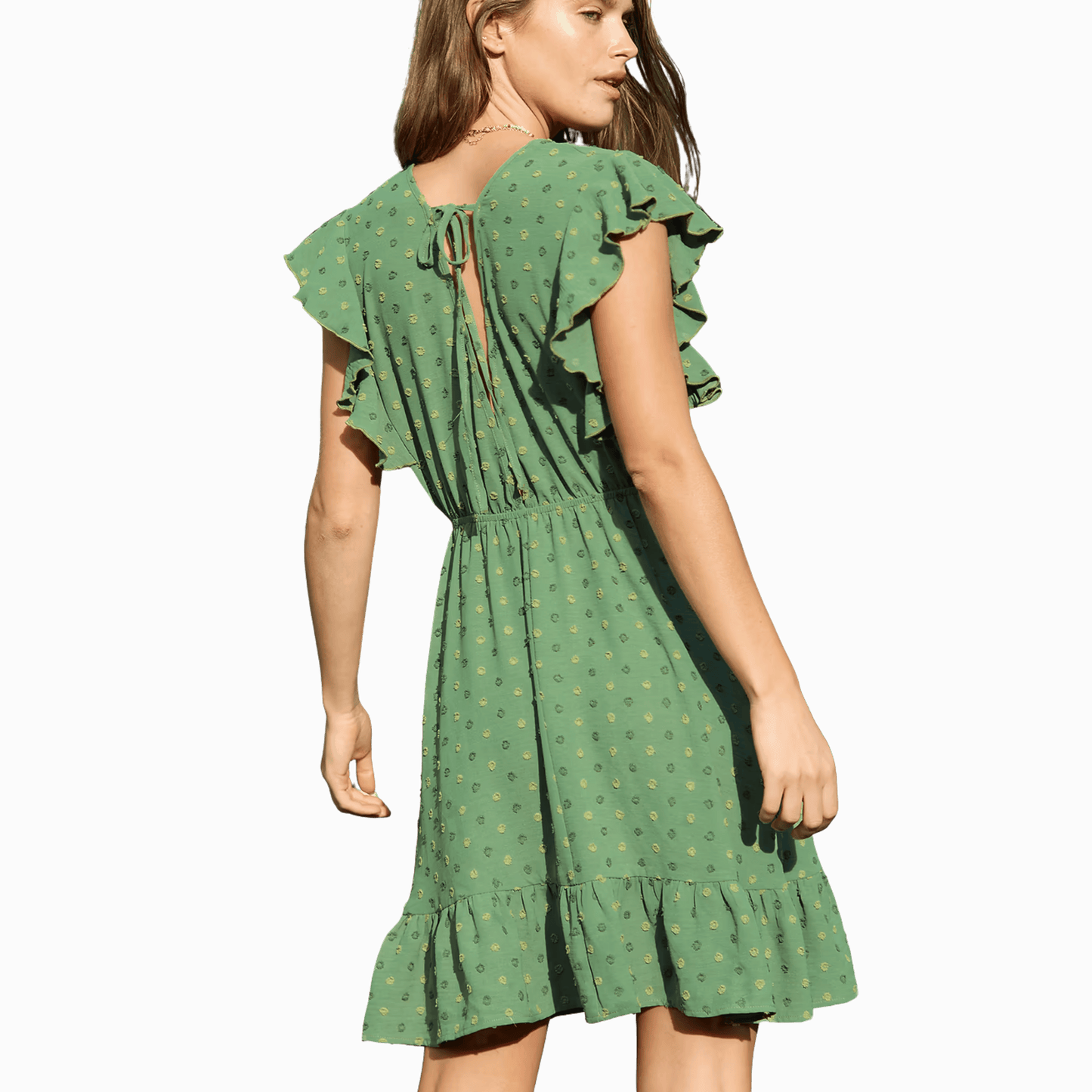 Green dress with ruffled sleeves and hem on a dark background