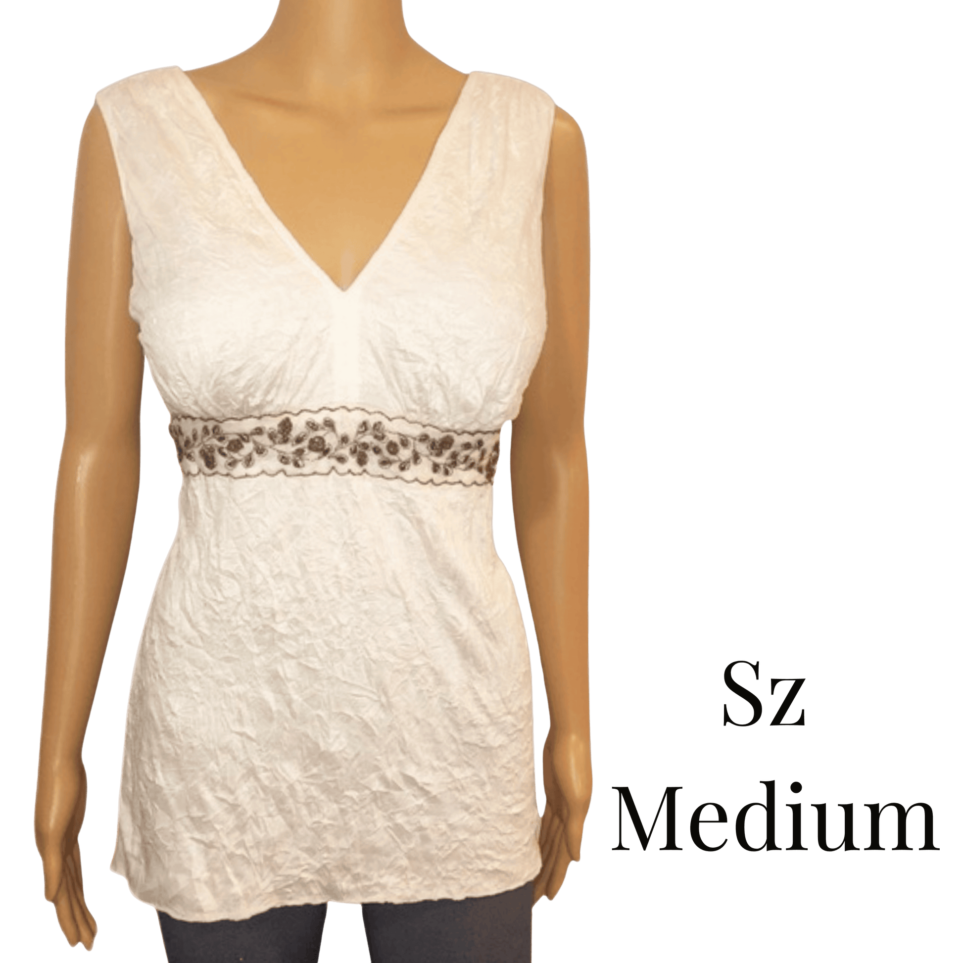 White sleeveless top with leopard print trim on a mannequin against a green background