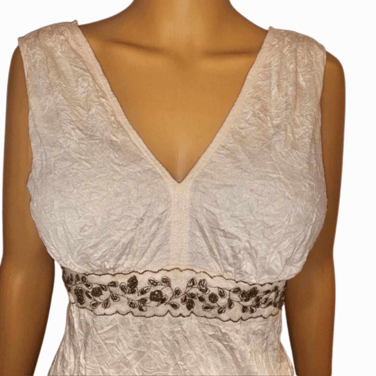 White lace dress with floral embroidery on a mannequin against a red background