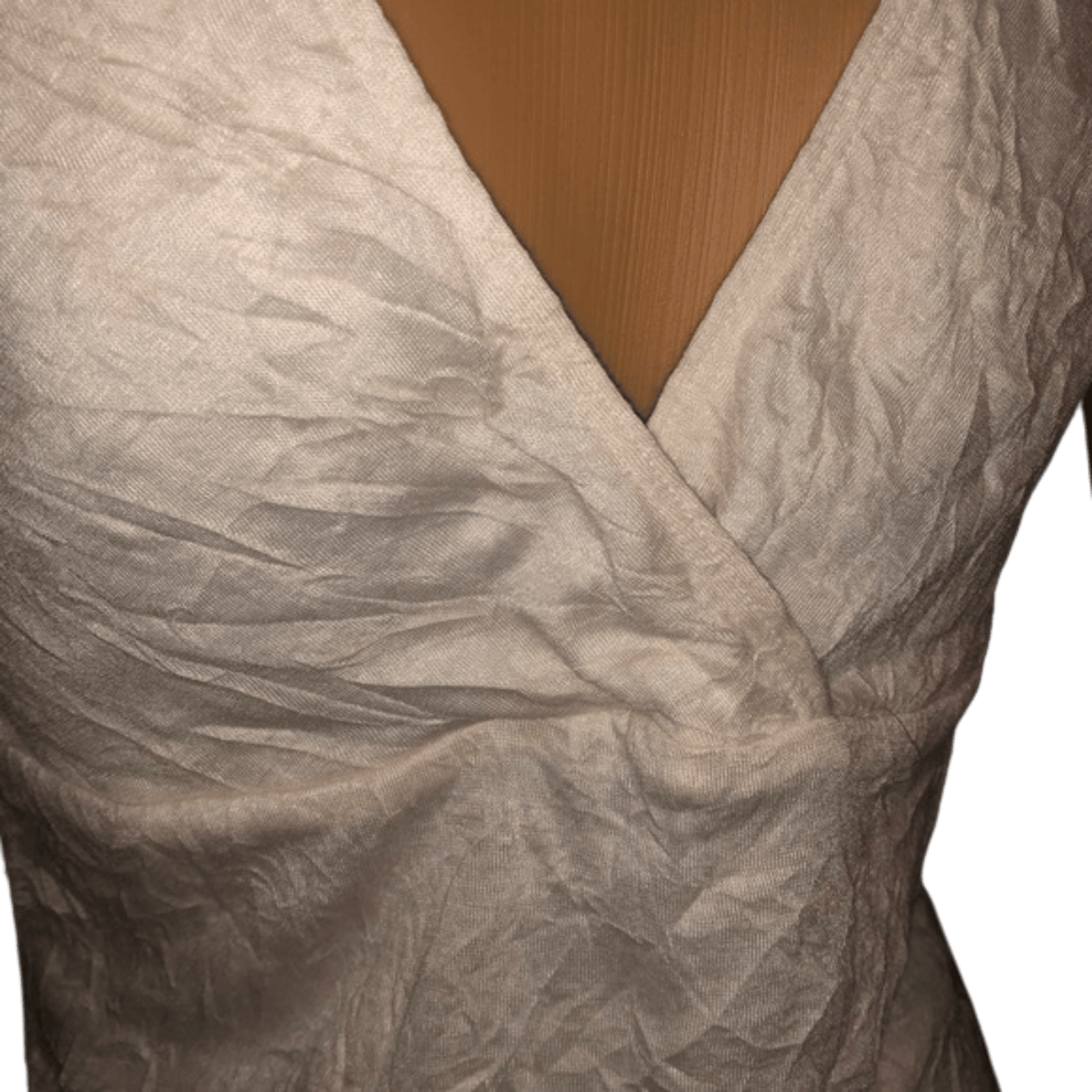 Close-up of a textured beige fabric with a V-neckline against a wooden surface.