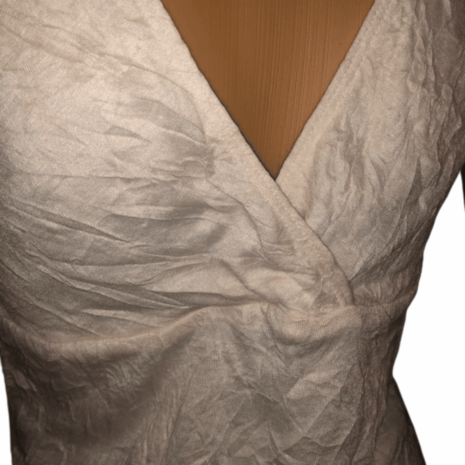 Close-up of a textured beige fabric with a V-neckline against a wooden surface.