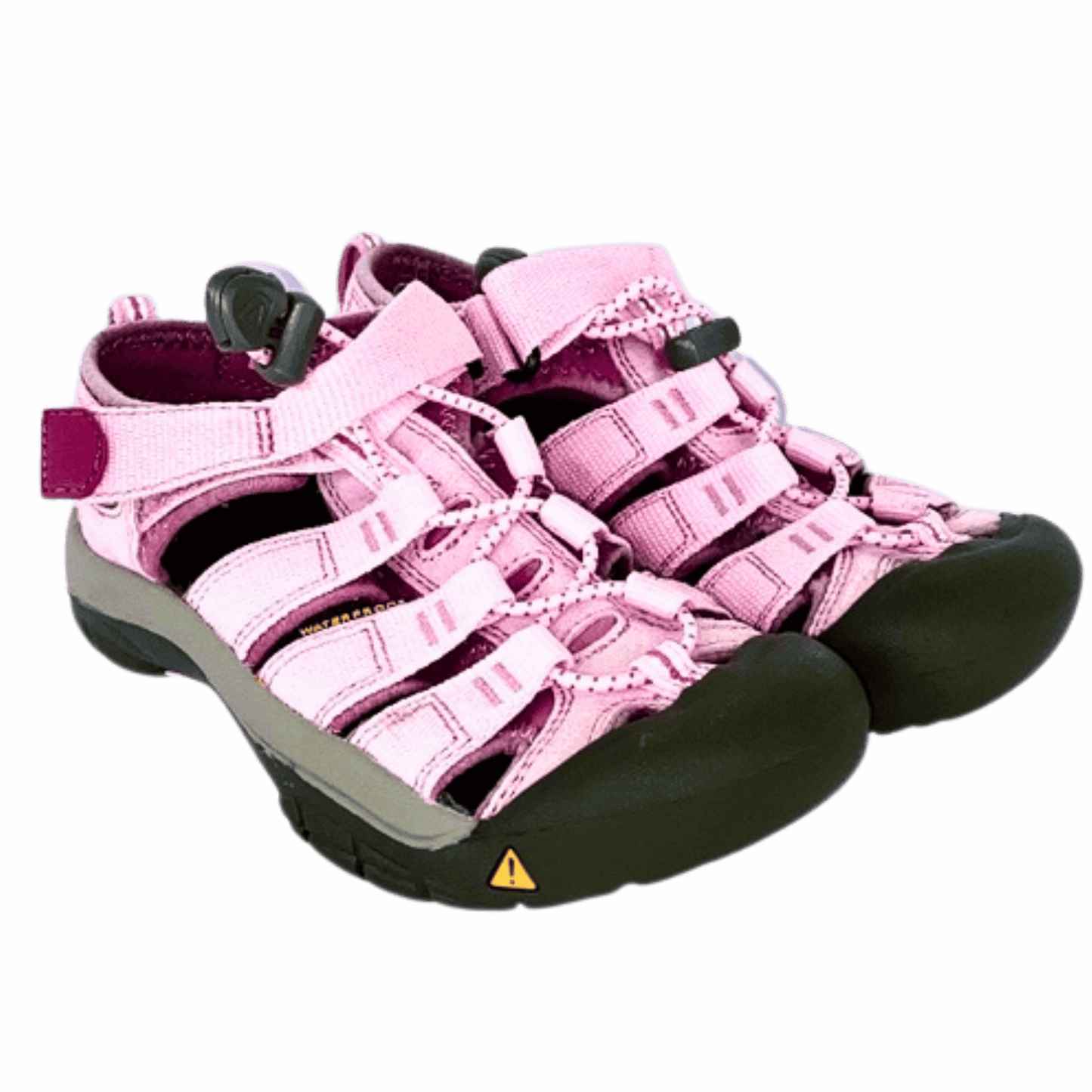 Pink children's sandals with black soles on a gray background