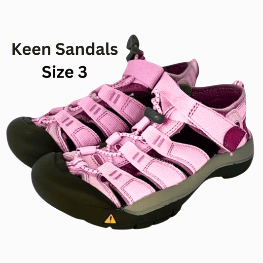 Pink Keen sandals with black soles on a gray background