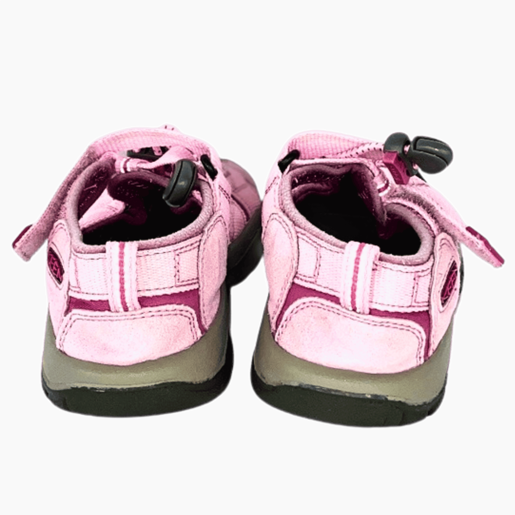 Pair of pink children's shoes with velcro straps on a gray background