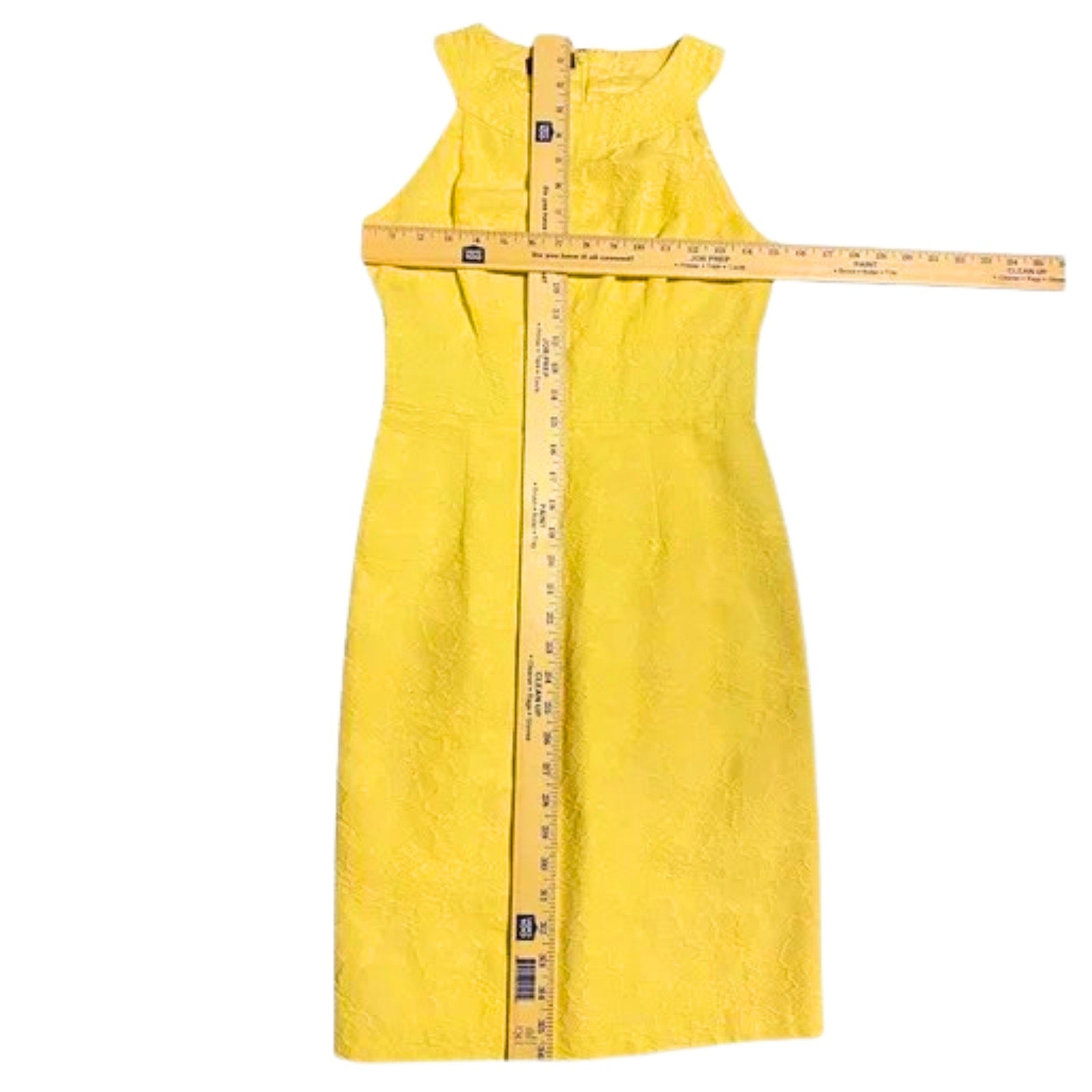 Yellow dress with a measuring tape on a white background