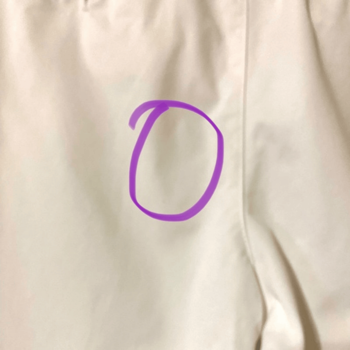 Purple circle on a beige fabric background