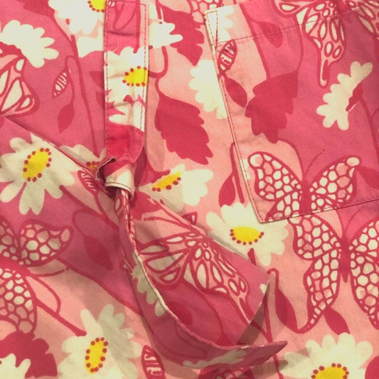Close-up of a pink floral fabric with butterfly and flower patterns.