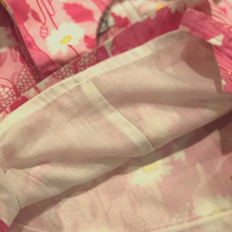 Close-up of a beige fabric with a pink floral background