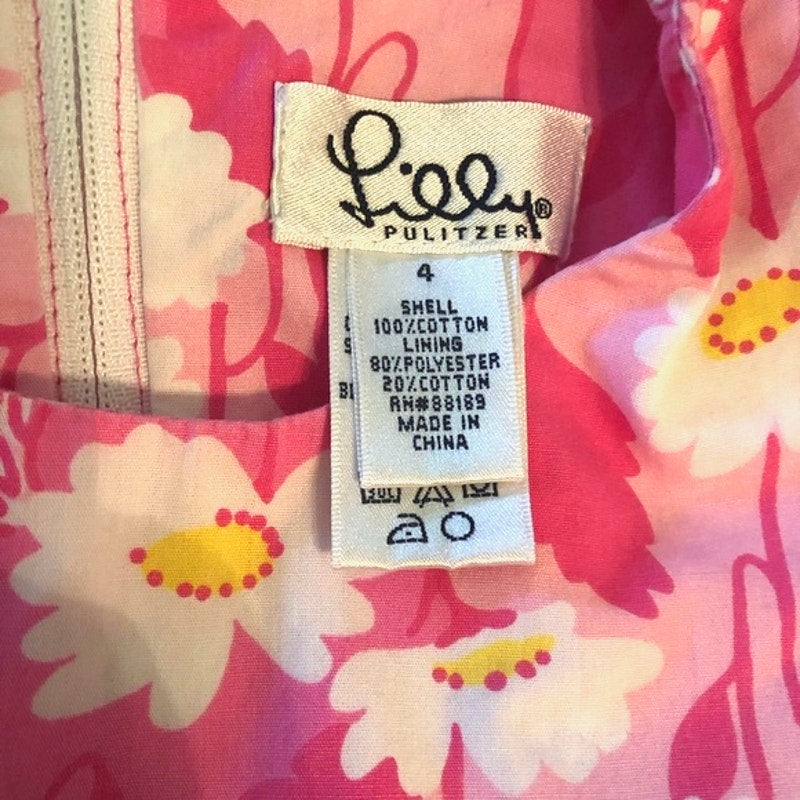 Close-up of a Lilly Pulitzer label on a floral garment with pink background