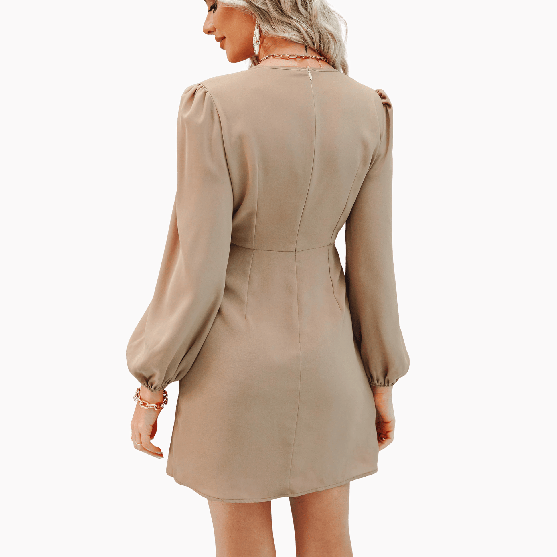 Woman wearing a beige dress with long sleeves on a brown background