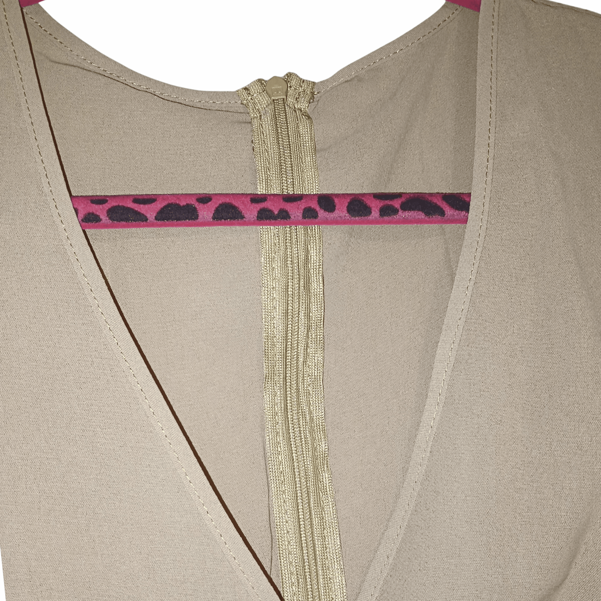 Close-up of a beige garment with a zipper and pink leopard print trim.