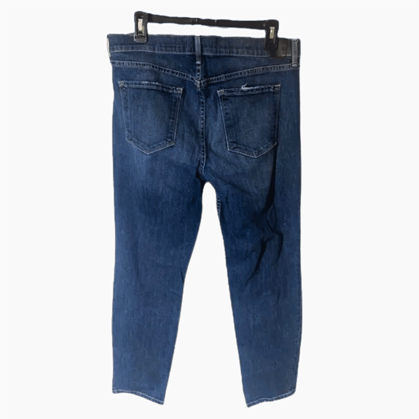 Blue jeans on a hanger against a dark blue background