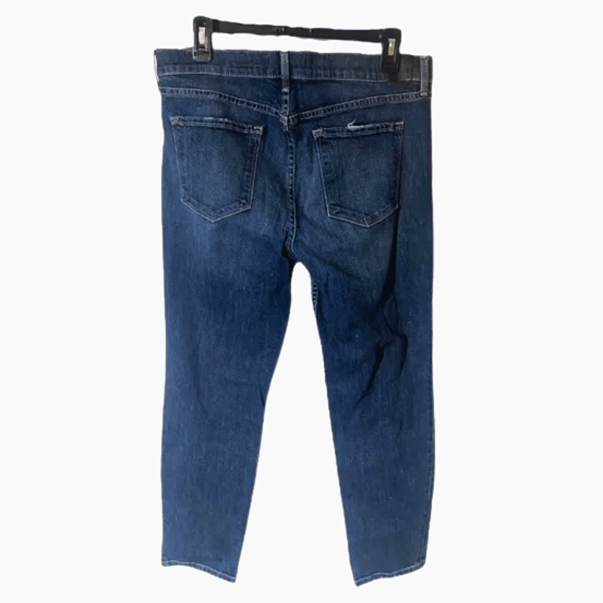 Blue jeans on a hanger against a dark blue background