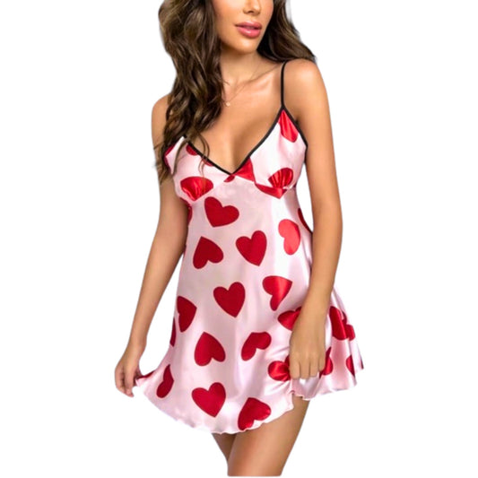 Woman wearing a pink nightgown with red heart patterns on a white background