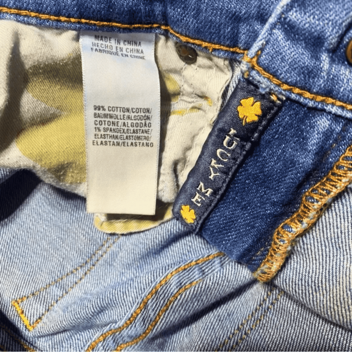 Close-up of a denim fabric with a brand label and care instructions.