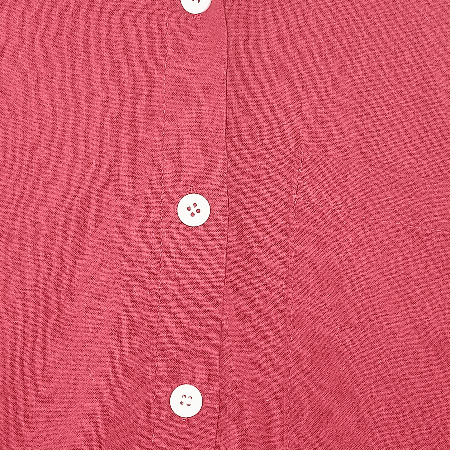 Close-up of a red shirt with buttons on a textured fabric background