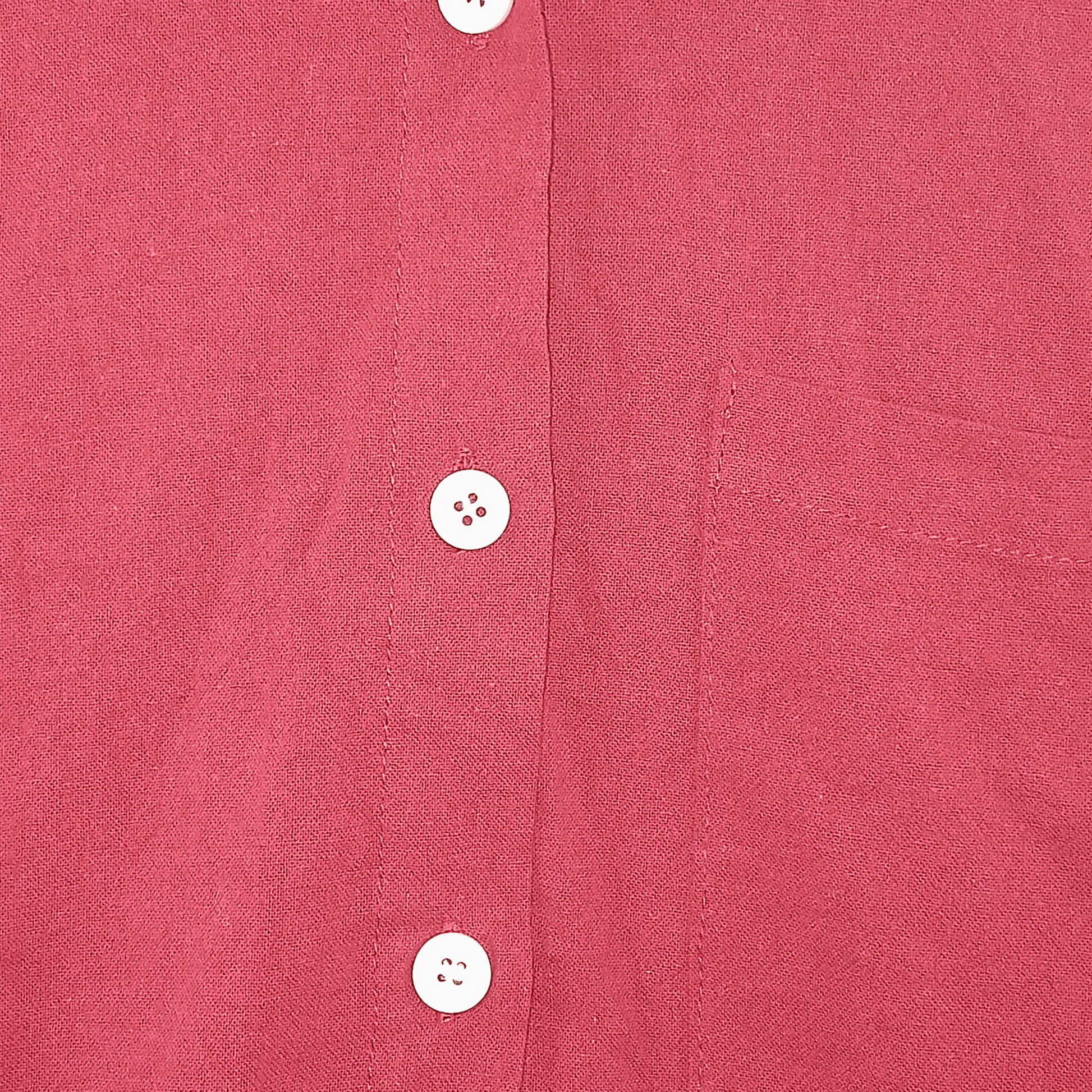 Close-up of a red shirt with buttons on a textured fabric background