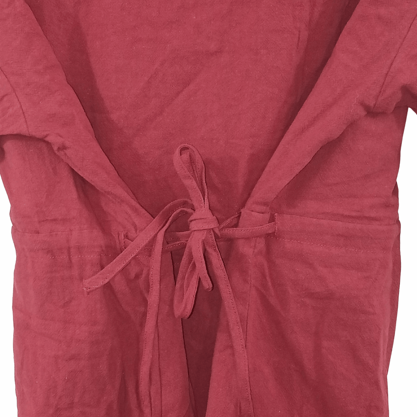 Close-up of a pink garment with a tie detail on a black background