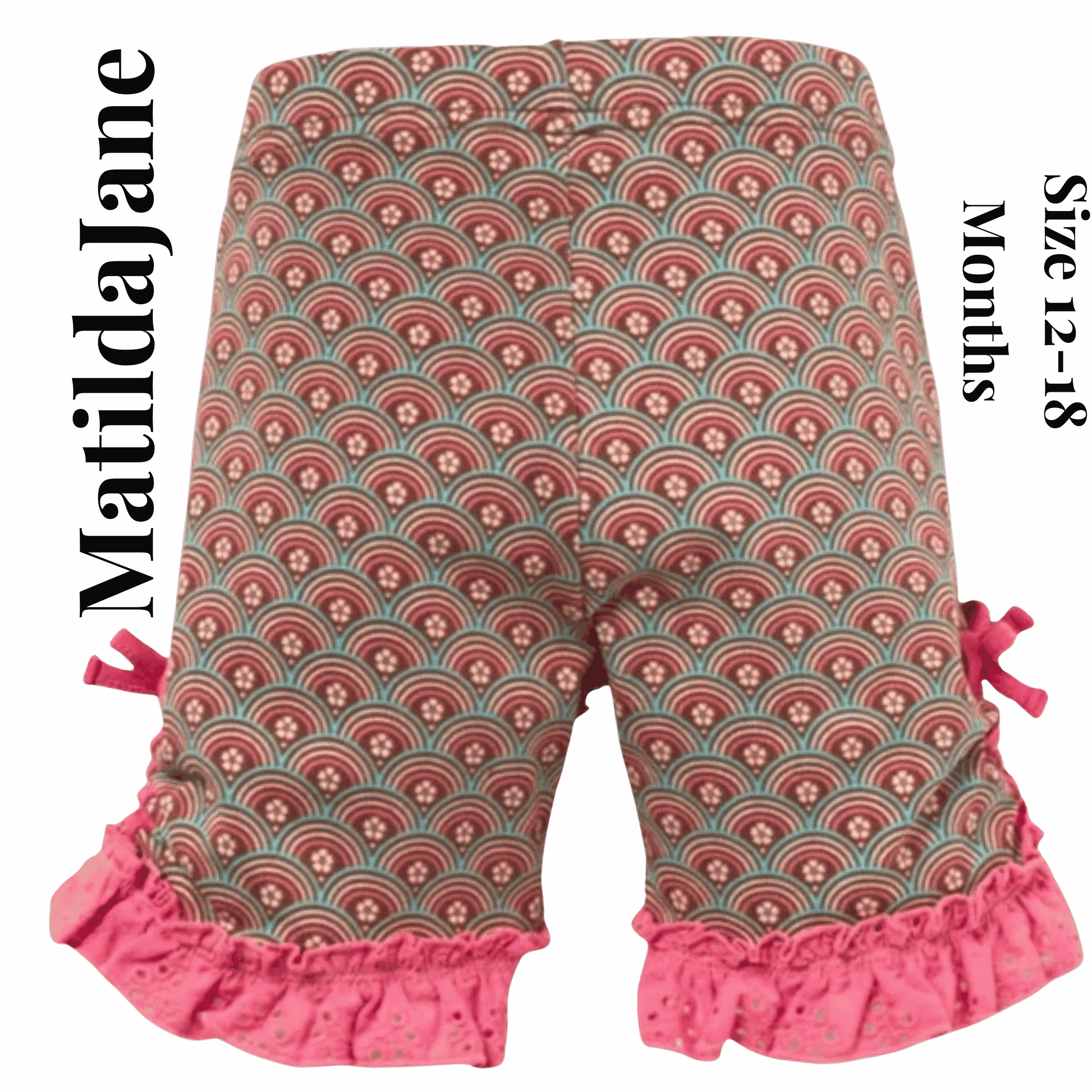 Patterned baby pants with ruffles on a pink background, featuring the brand 'Matilda Jane'.
