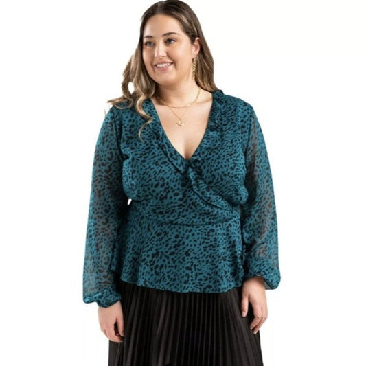 Woman wearing a teal leopard print top with a white background