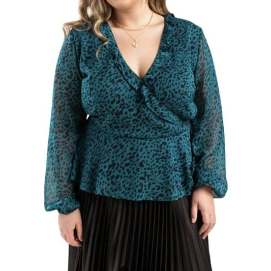 Teal leopard print blouse worn by a person on a white background