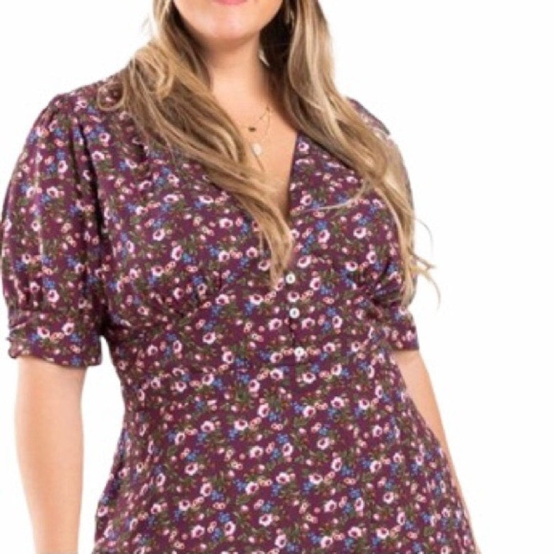 Woman wearing a floral dress with a plain background