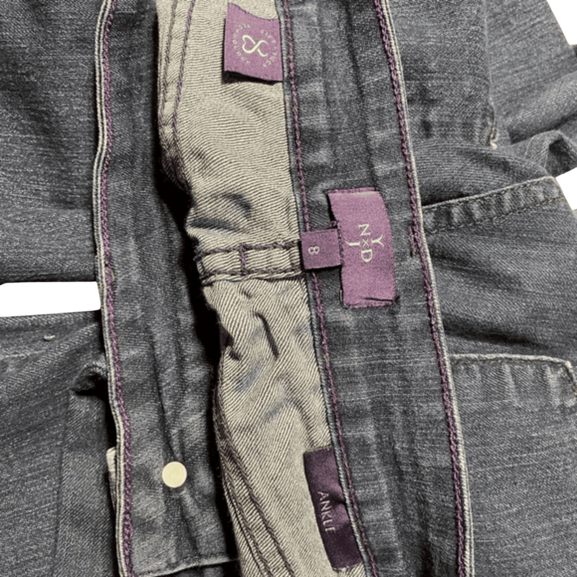 Close-up of a gray jacket with purple labels on a green background