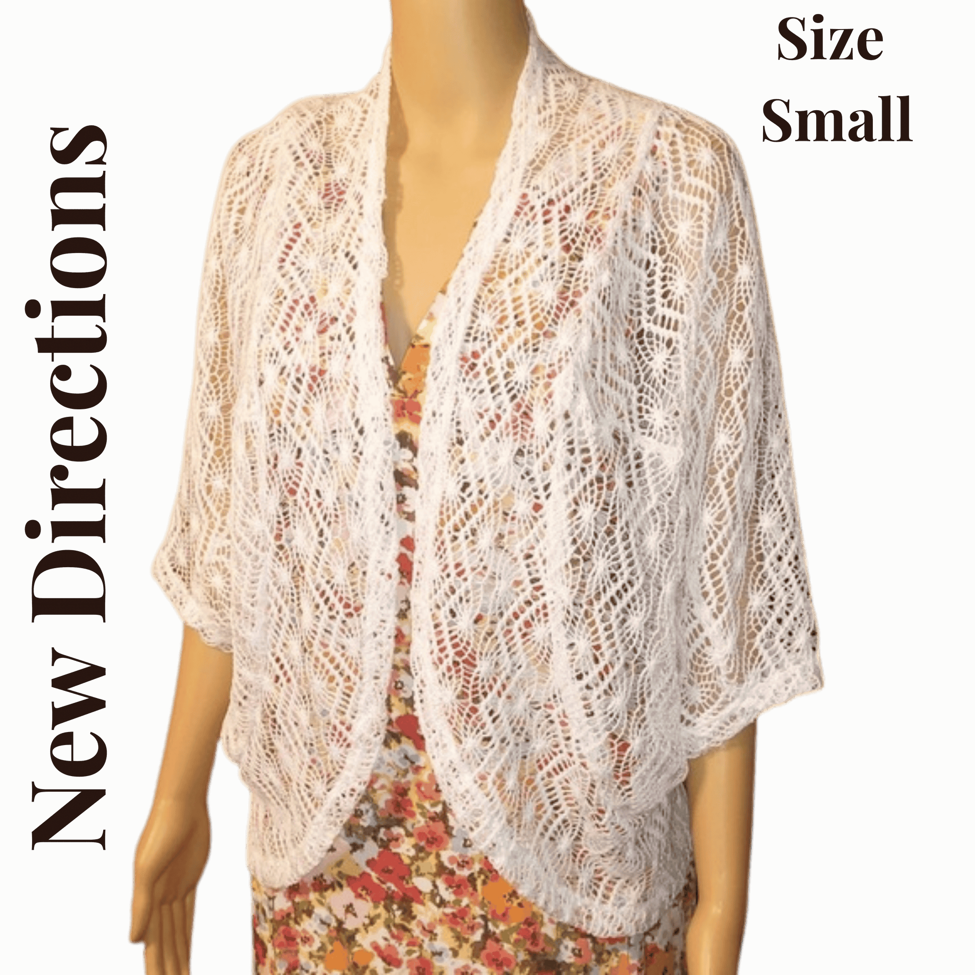 Mannequin wearing a white lace shrug with text indicating size small and brand 'New Directions' on a green background.