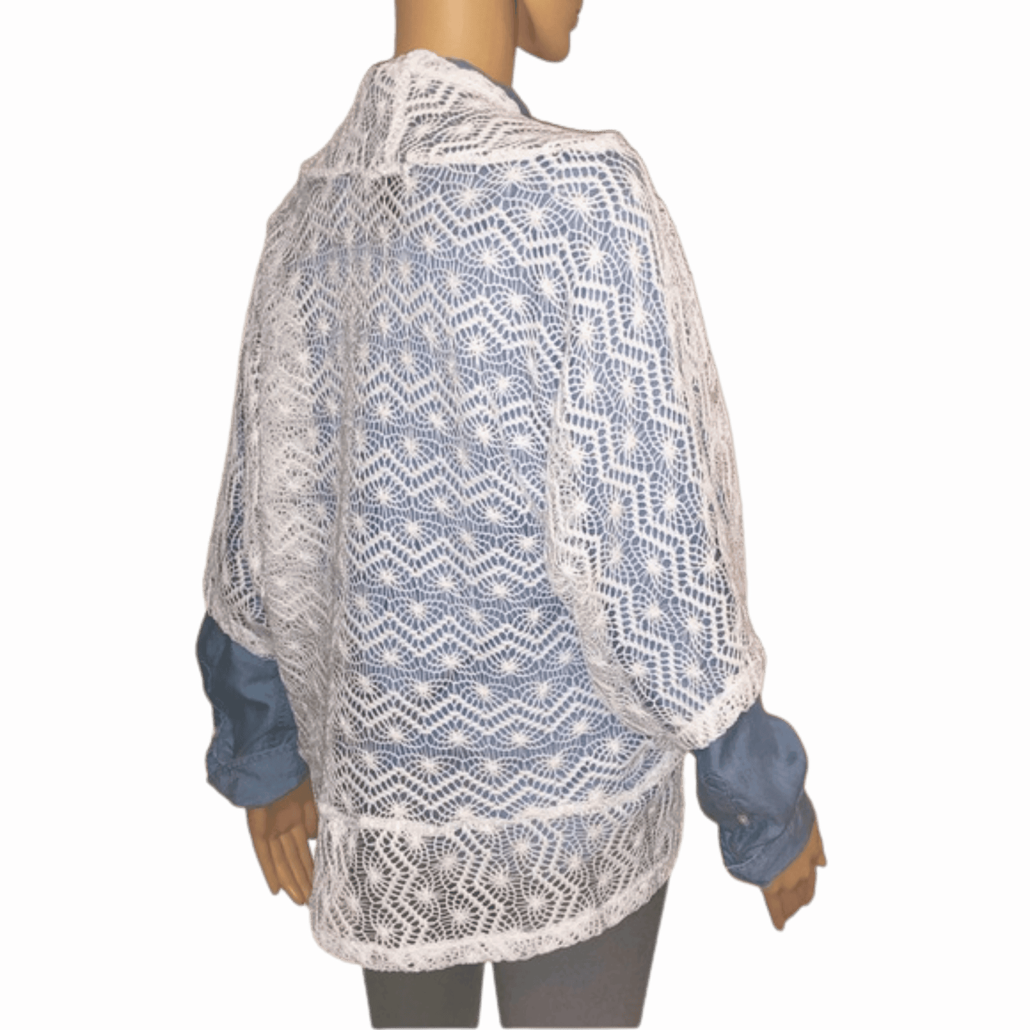 Mannequin wearing a blue and white patterned lace shawl on a red background
