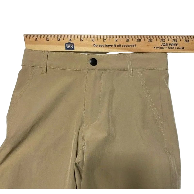 Beige pants with a ruler above them on a white background