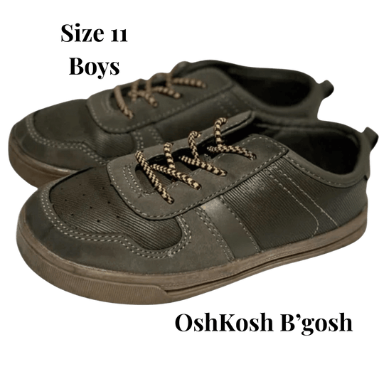 Pair of green boys' shoes with laces on a transparent background, featuring OshKosh B'gosh branding.