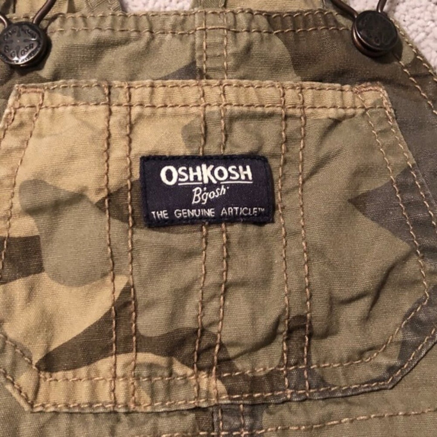 OshKosh B'gosh label on a camouflage fabric background