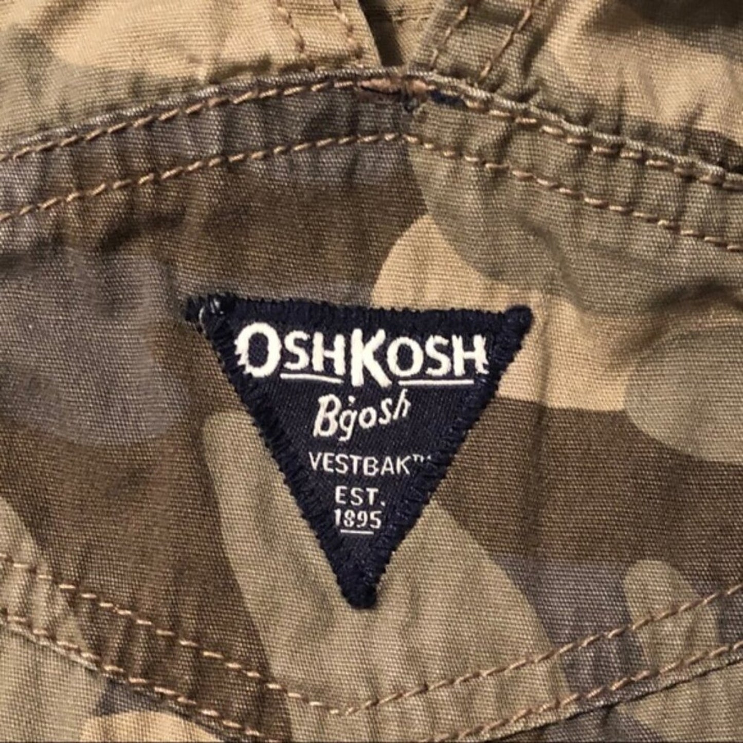 OshKosh Bégot logo on a camouflage jacket