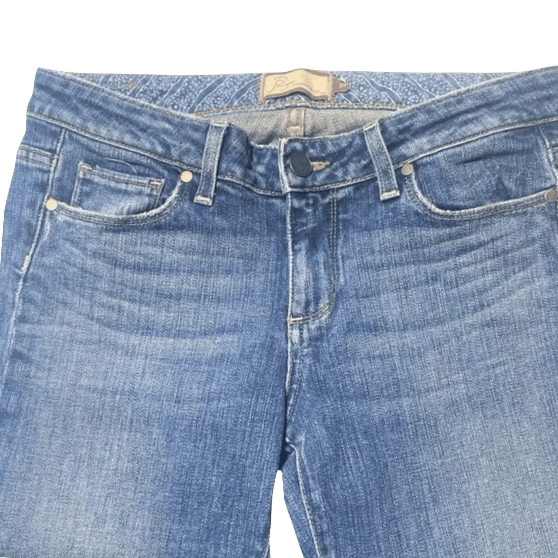 Close-up of blue jeans with a brand label on a green background