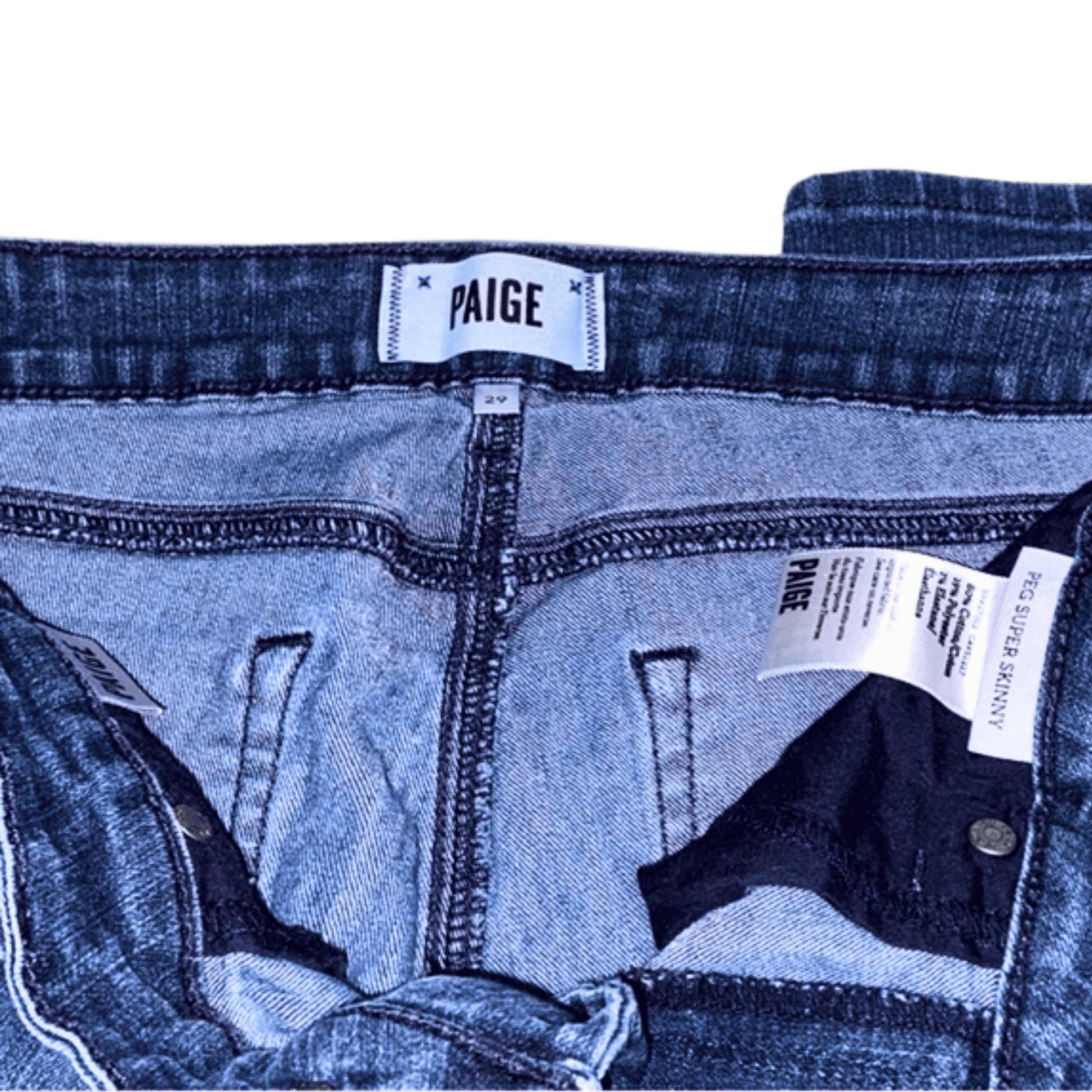Close-up of blue jeans with 'Paige' brand labels on a green background