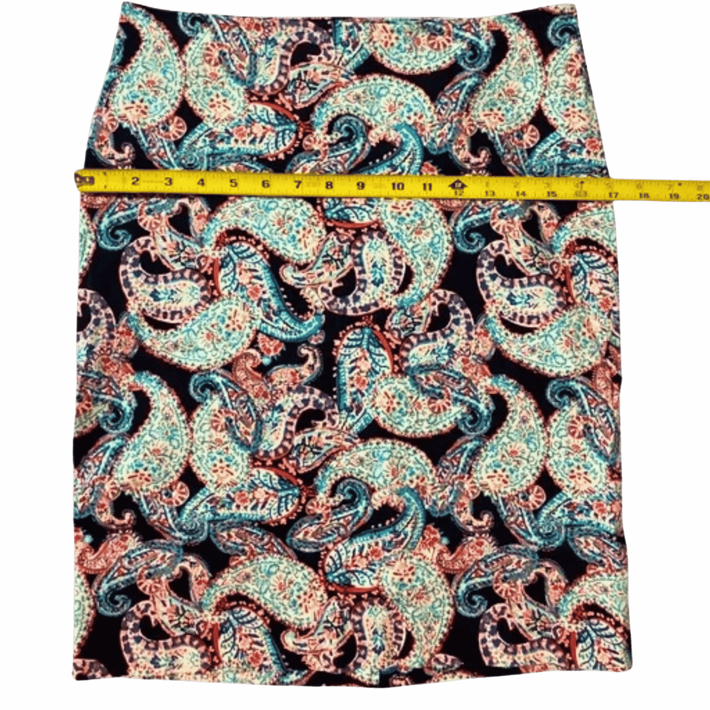 Paisley patterned fabric with a measuring tape on a gray background
