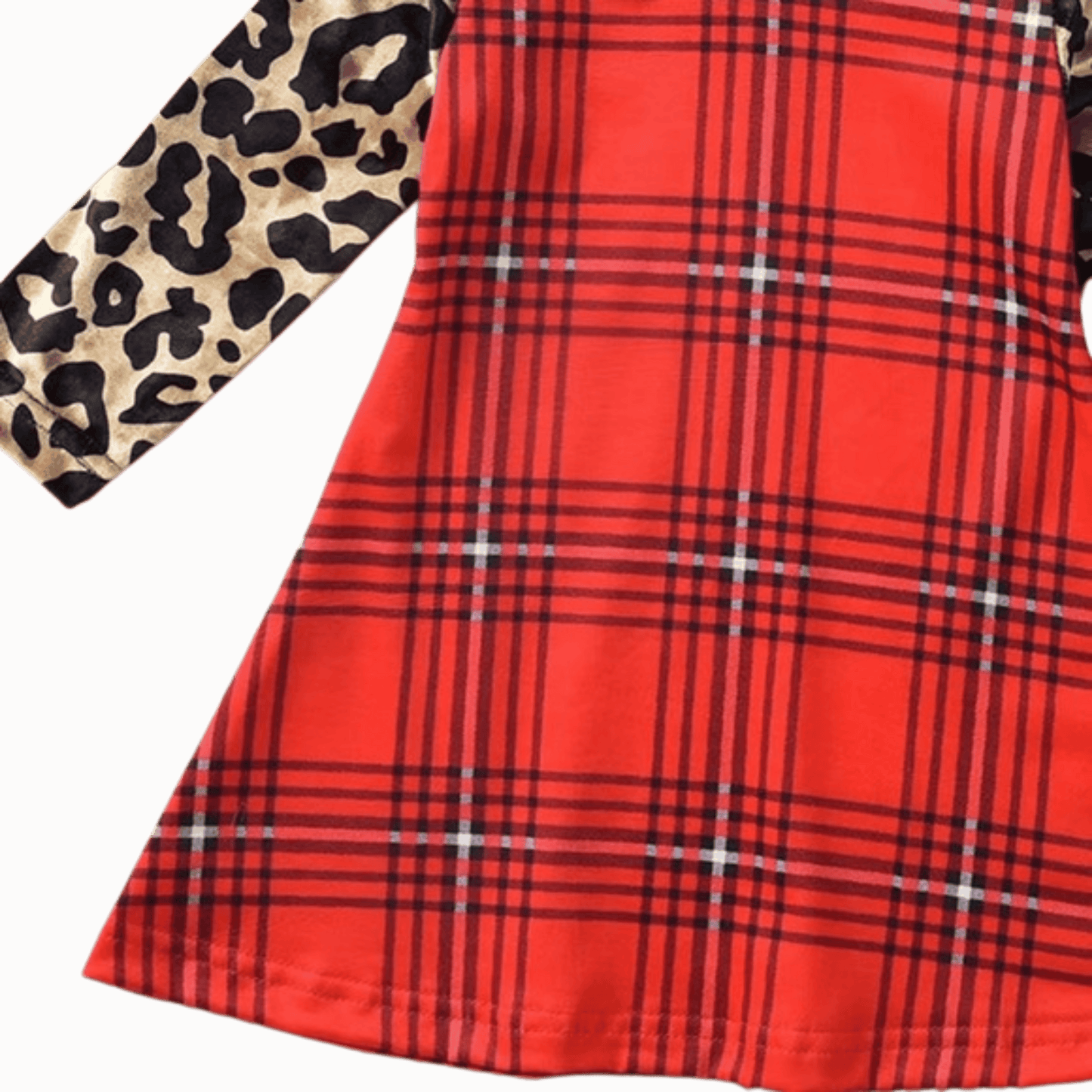 Red plaid fabric with a leopard print fabric swatch on a brown background