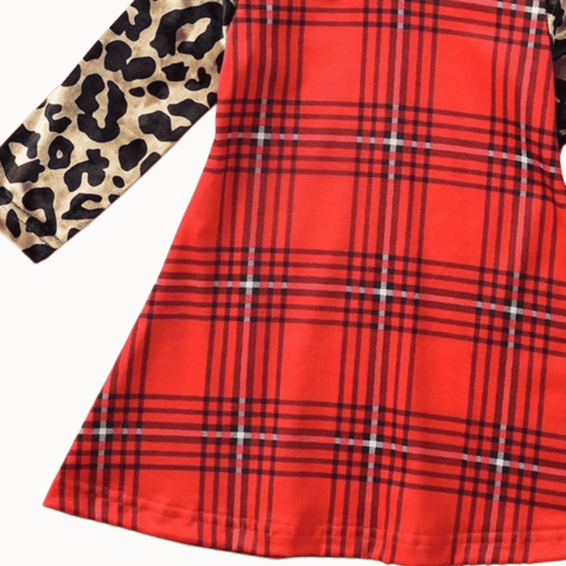 Red plaid fabric with a leopard print fabric swatch on a brown background