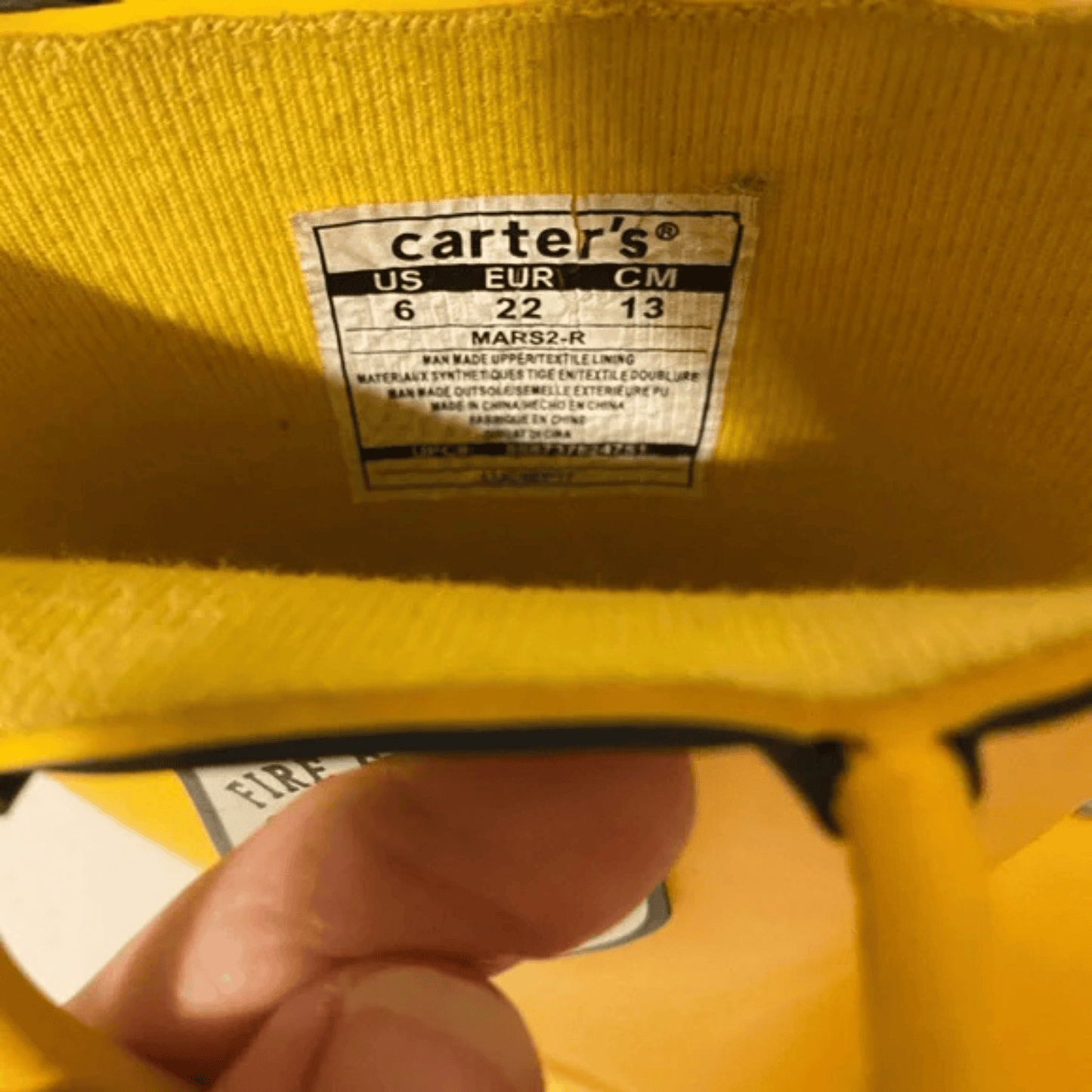 Yellow jacket with a Carter's size label on a blurred background