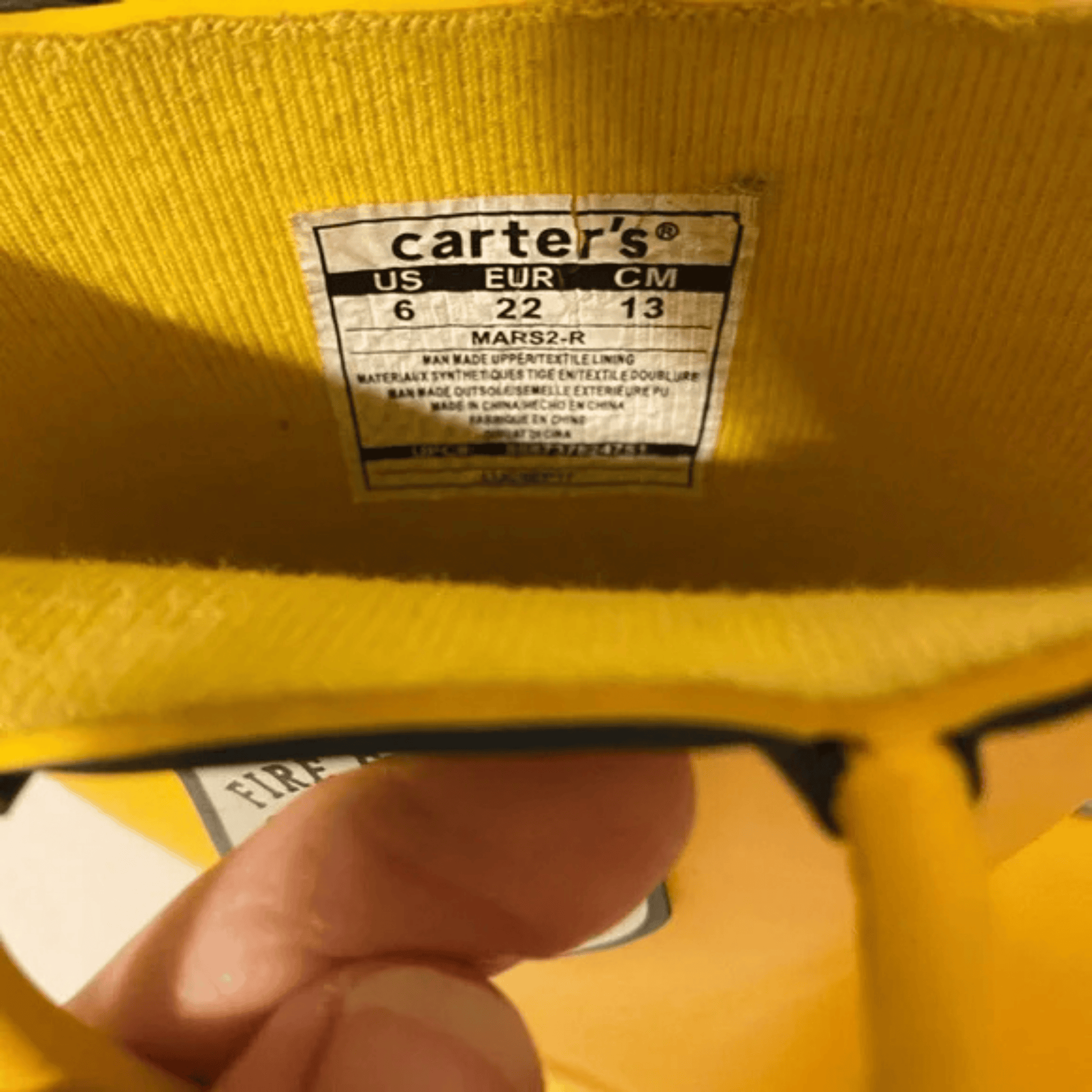 Yellow jacket with a Carter's size label on a blurred background