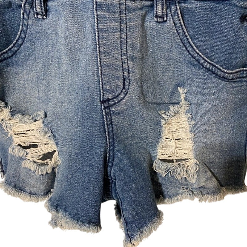 Close-up of distressed denim shorts with frayed edges on a white background
