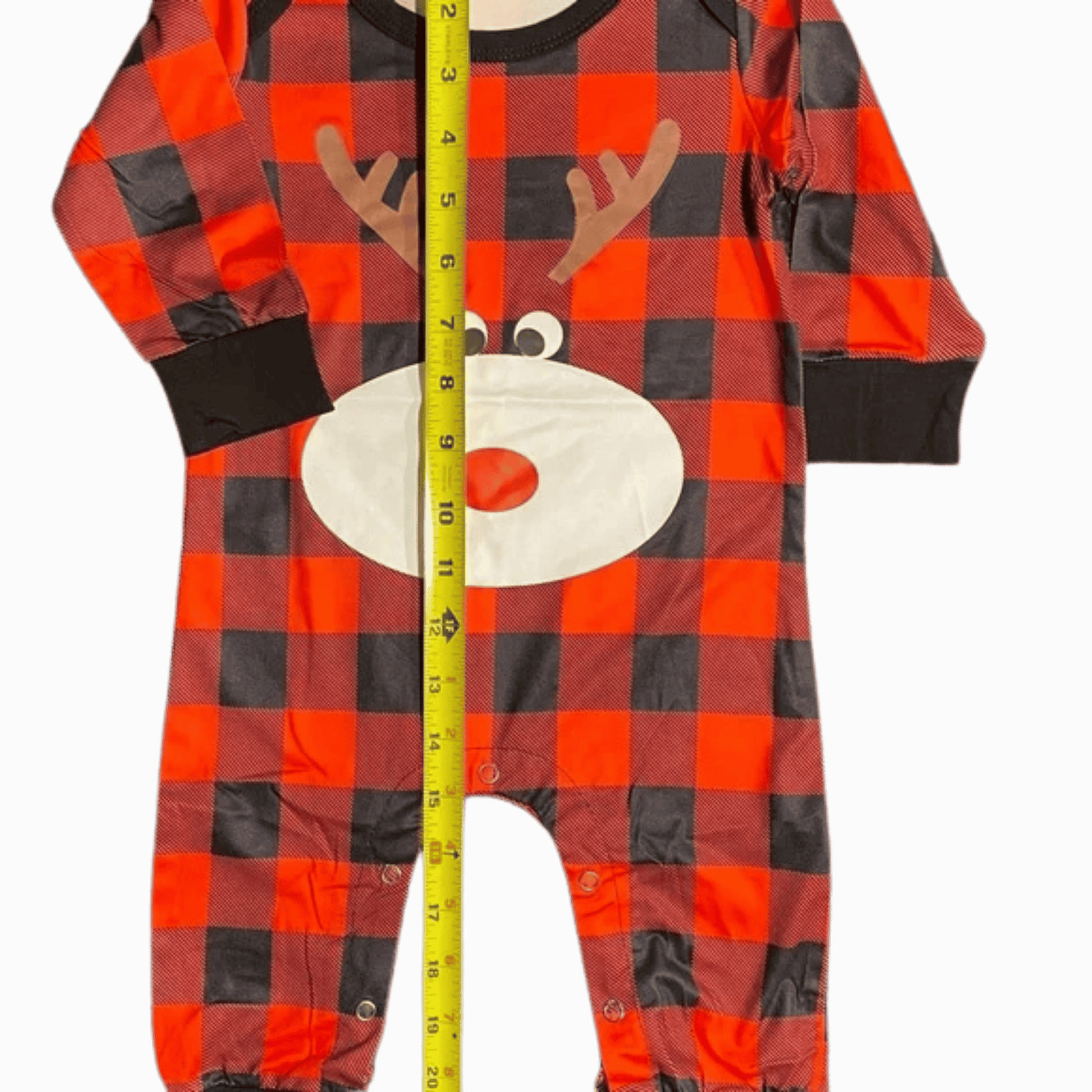 Red and black checkered onesie with reindeer design, measured by a tape measure on a dark red background.