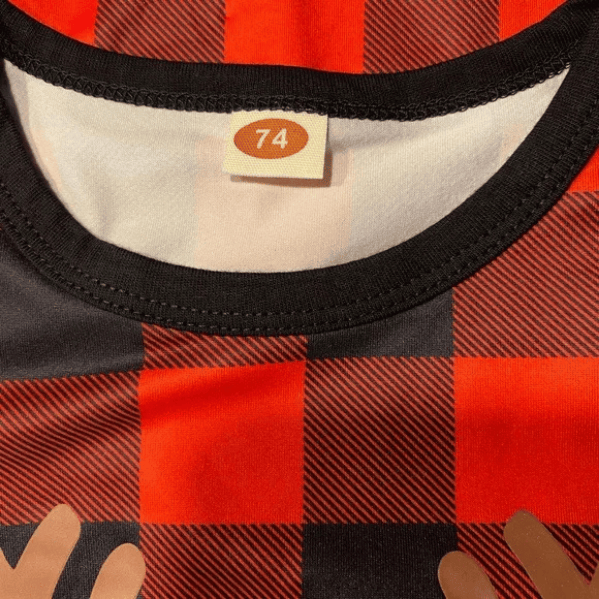 Red and black checkered fabric with a size tag on a white background