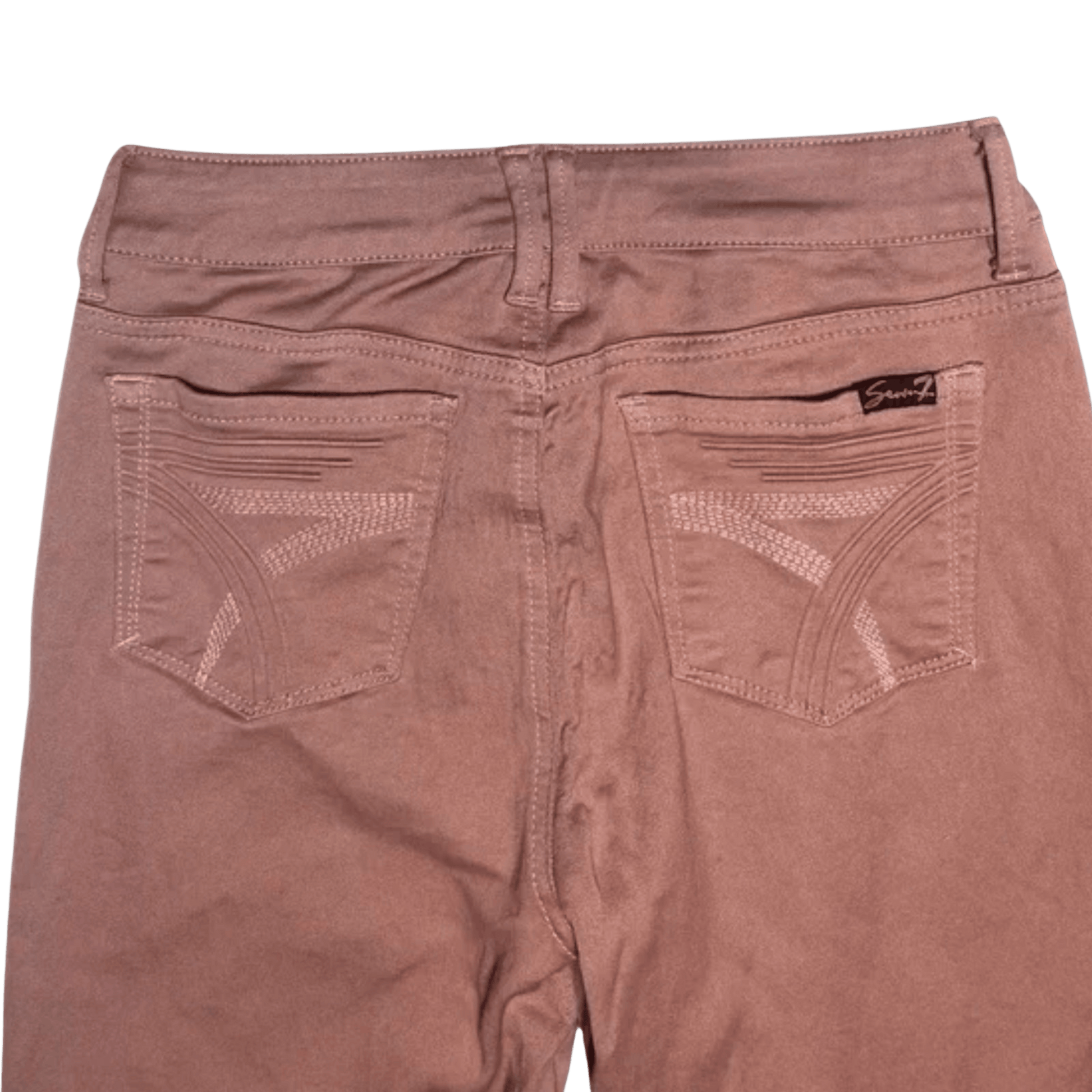 Brown pants with a visible brand label on a green background