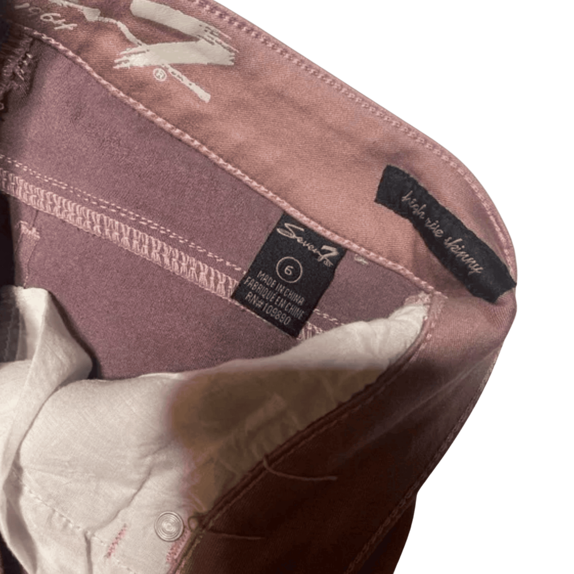 Close-up of a brown jacket with brand labels on a green background