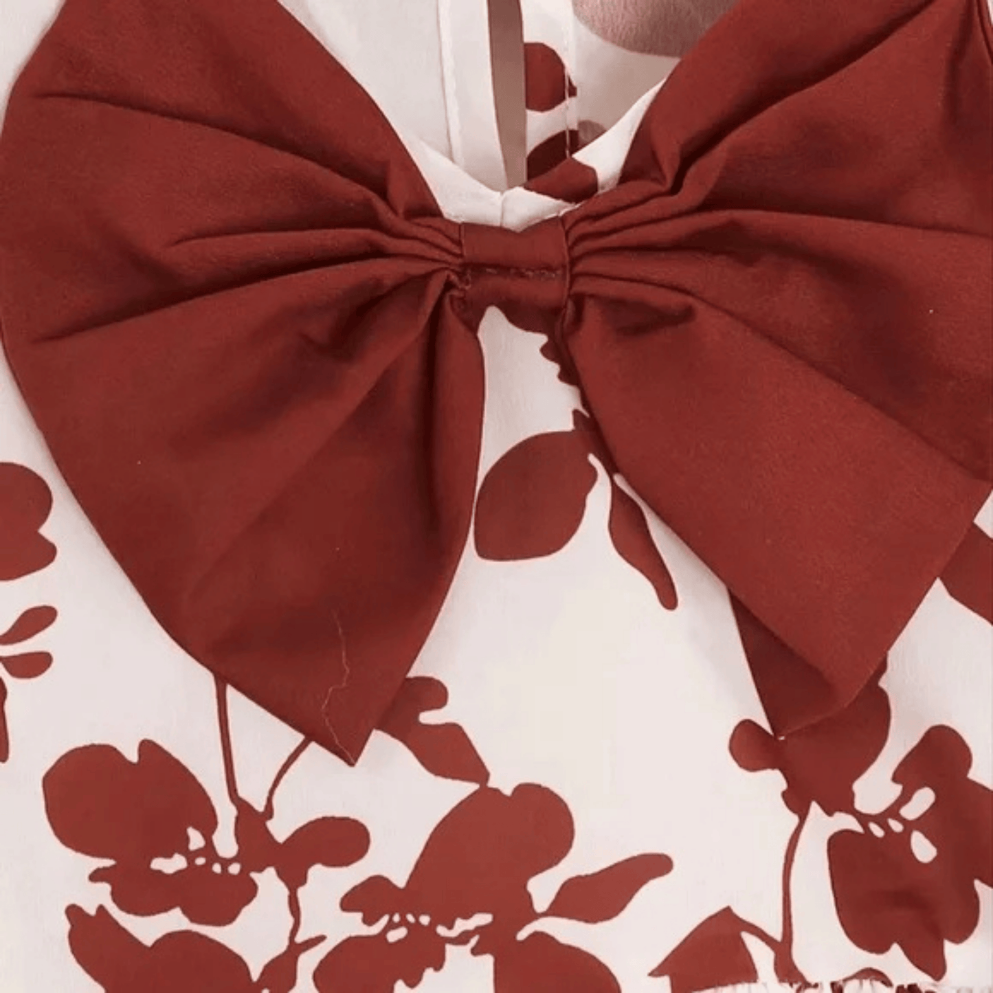 Close-up of a red bow with floral patterned fabric