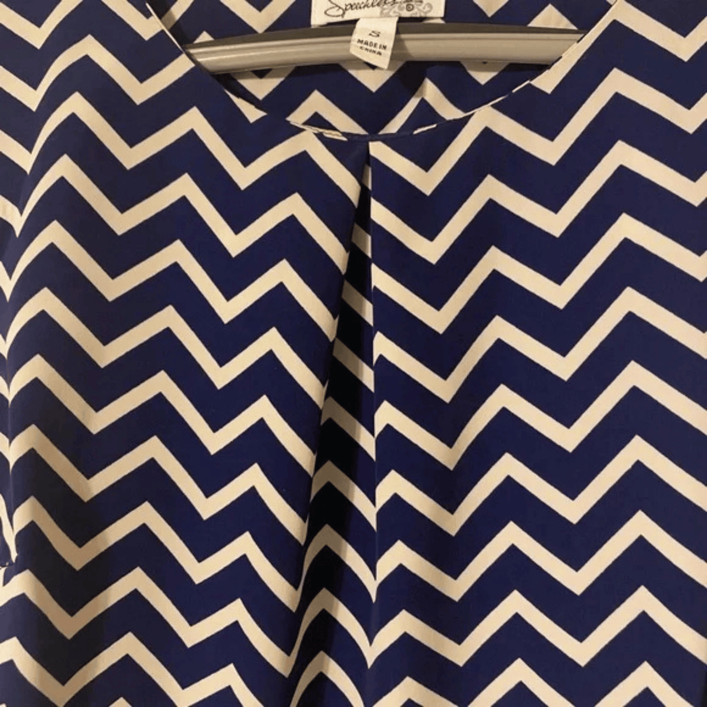 Navy and white chevron patterned shirt on a hanger